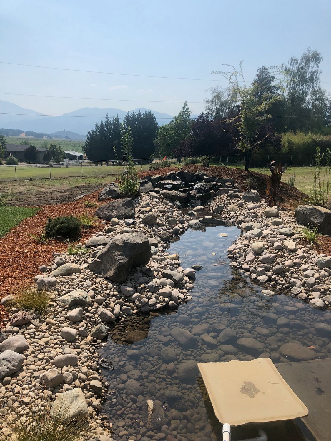 Natural stone water feature running through a landscaped property
