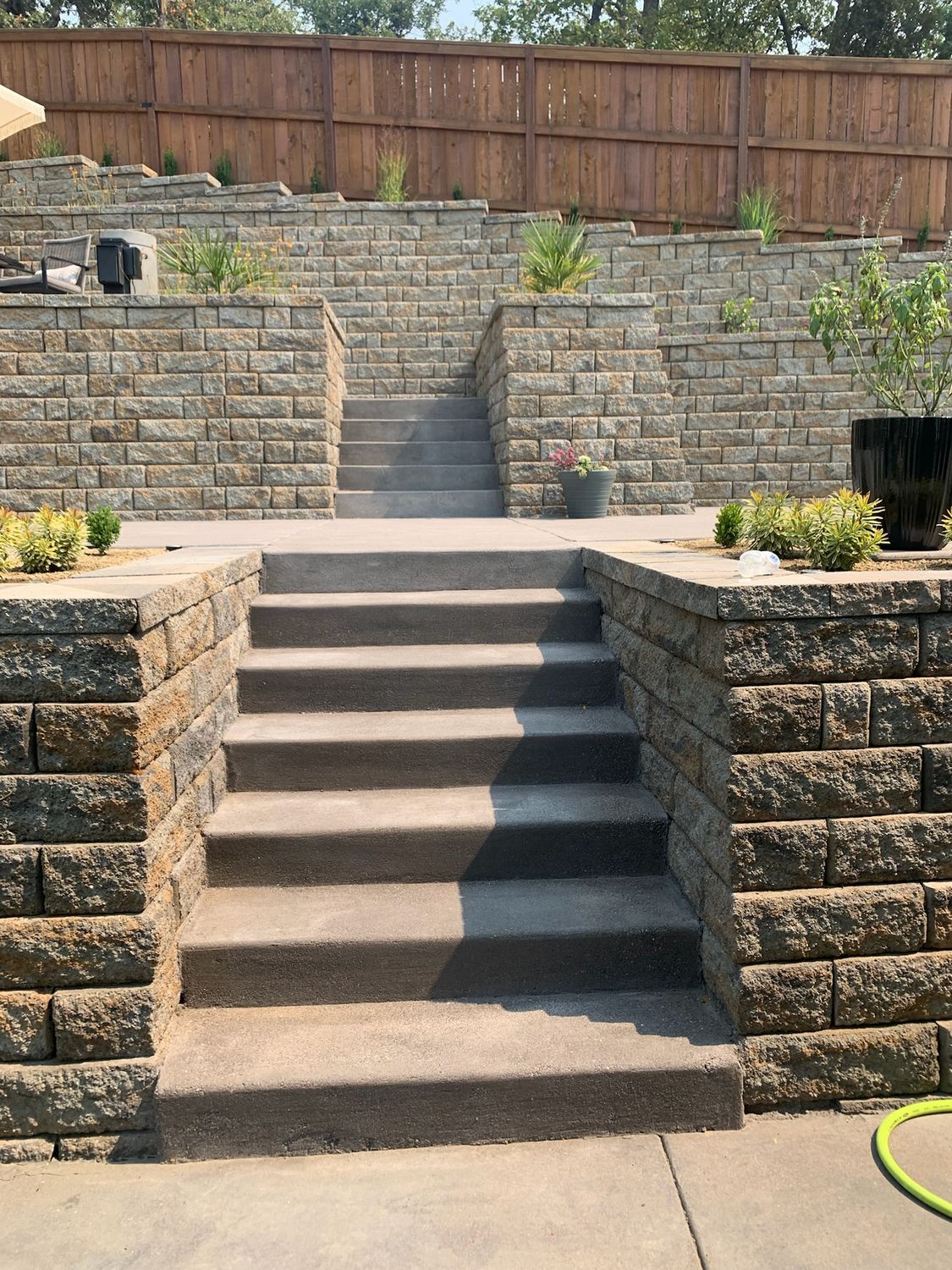 Block retaining walls and steps within a planted landscape