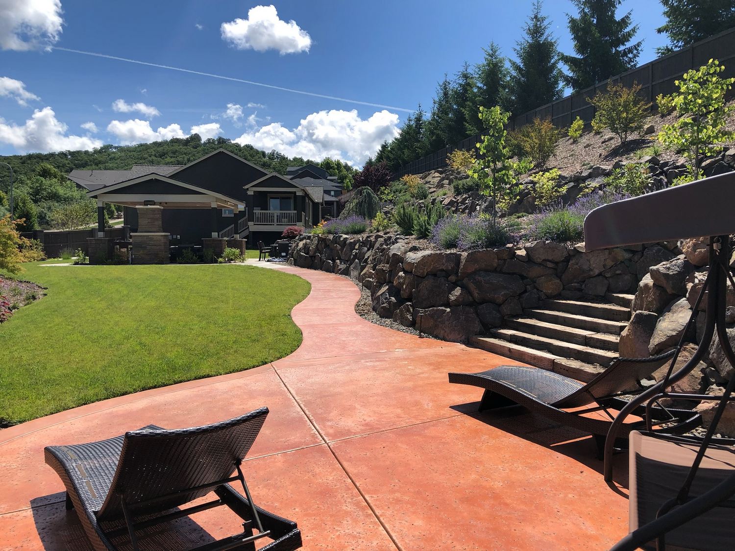 Curved path, lawn, retaining rock, and planted slope