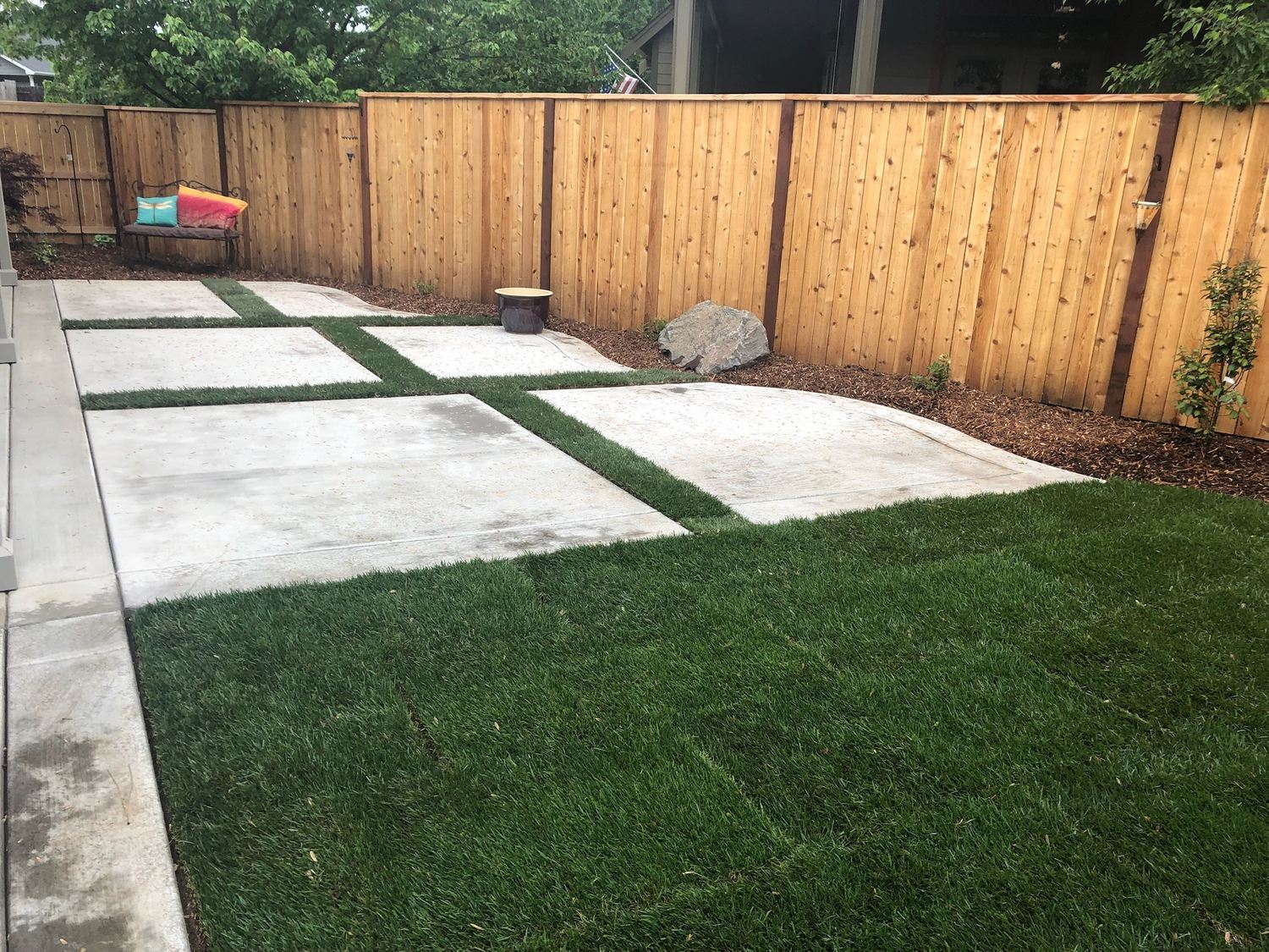 Finished lawn area with stepping-pad hardscape and a wood fence